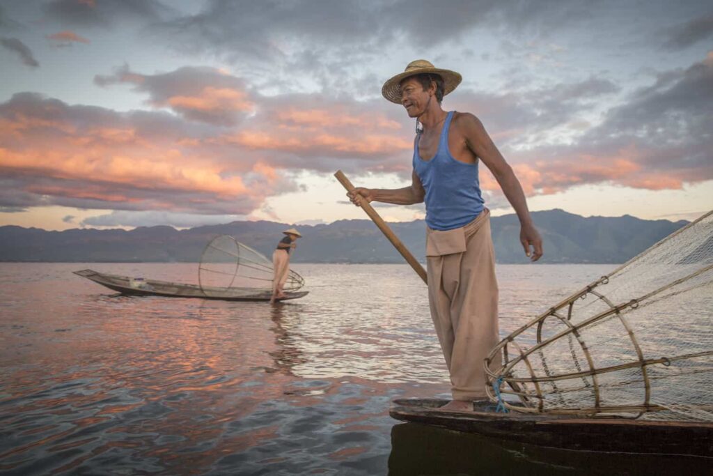 Fishermen in the sea holding their traditional conical fishing net