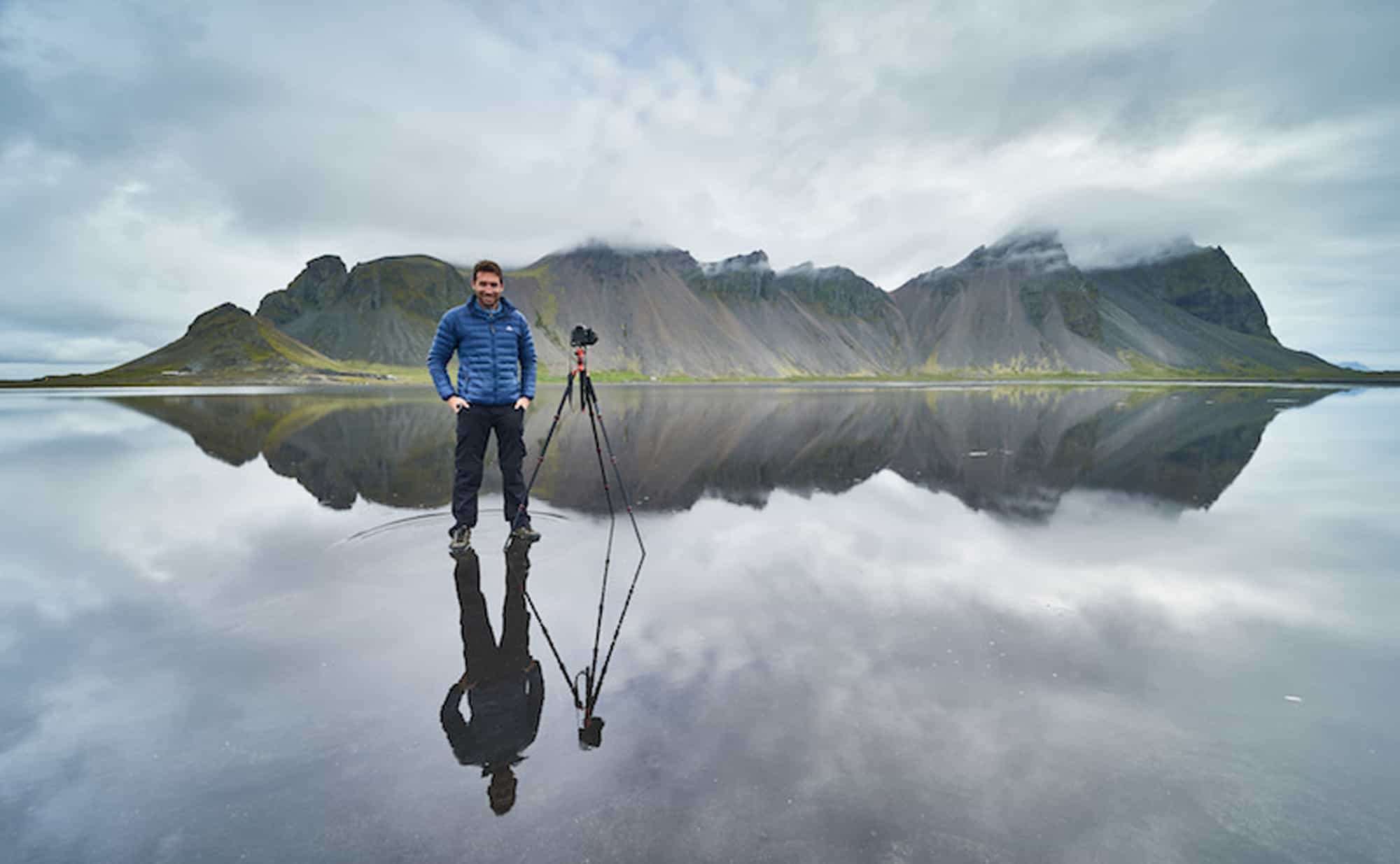 photographer standing in front of mountains