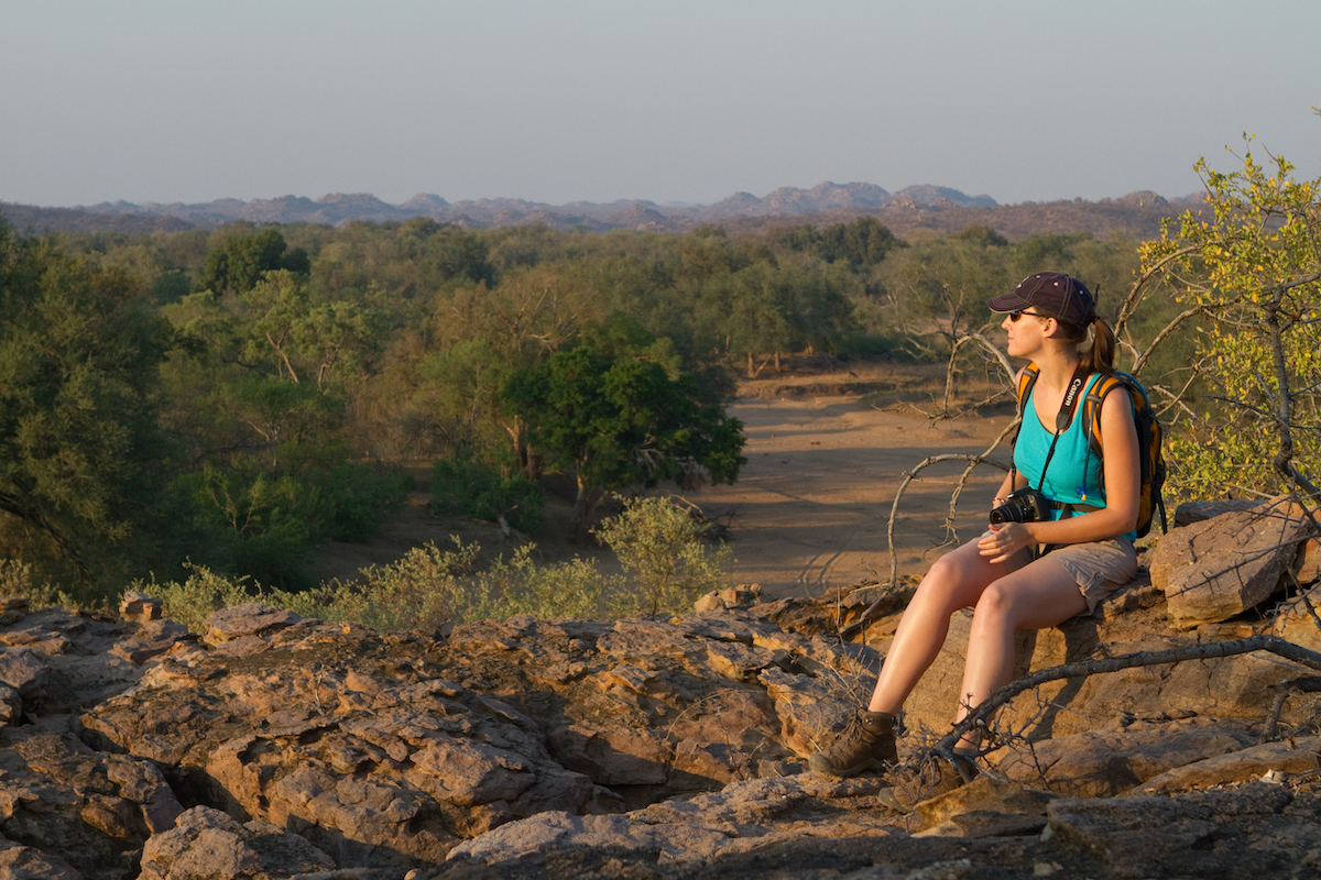 a woman sitting on a rock