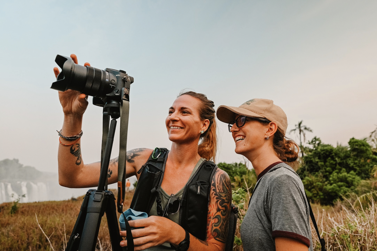 a woman holding a camera and showing it to another woman beside her