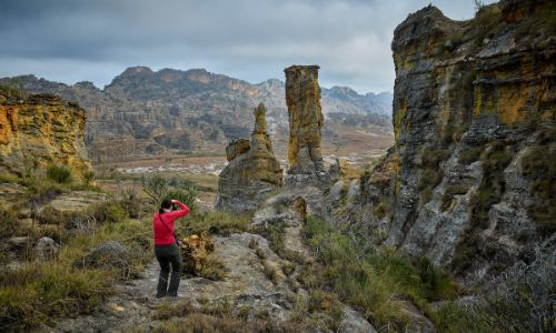 a woman photographer taking a photo of a rock formation