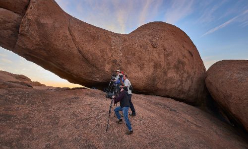 photographers standing in big rock formations in Namibia