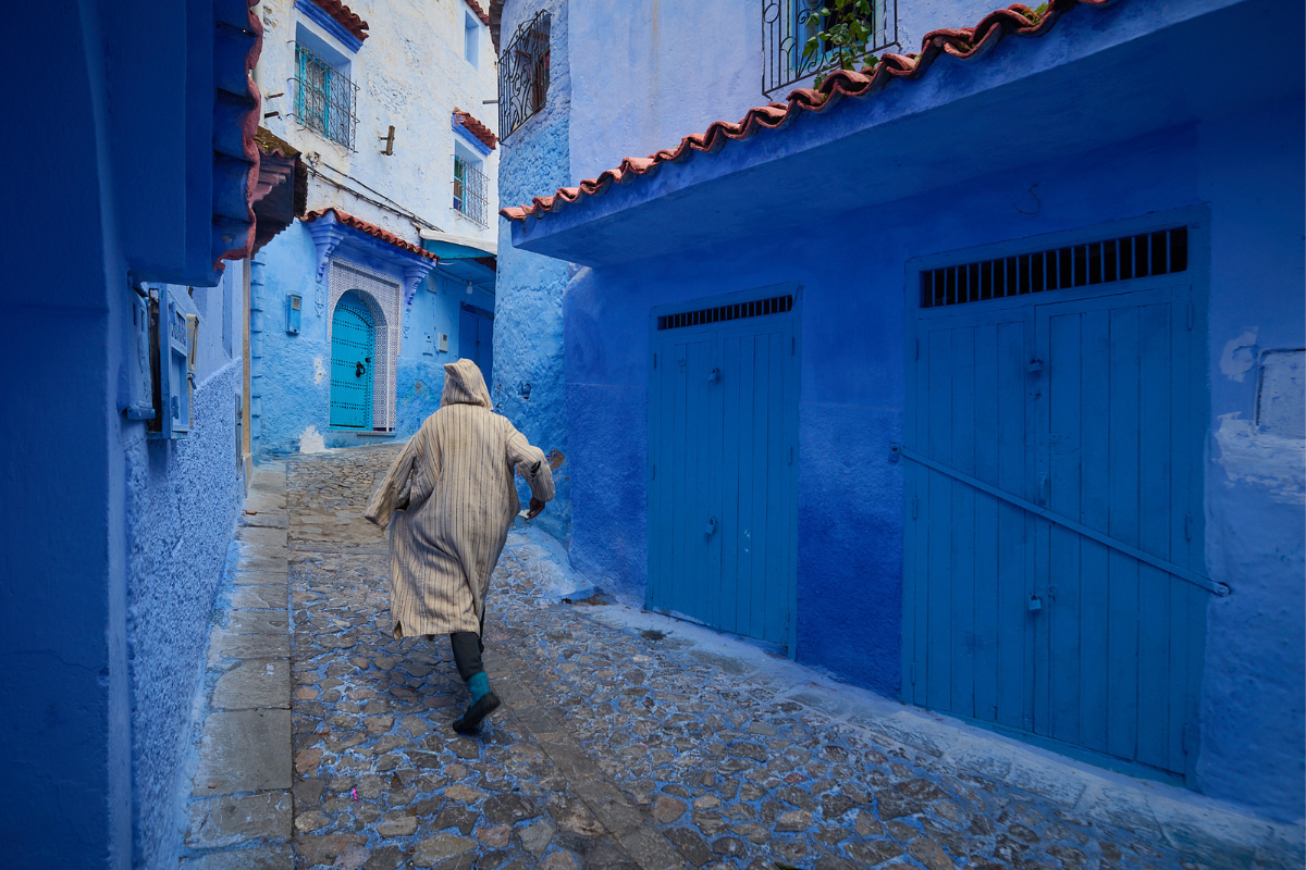 Man walking through the blue walls of Chefchaouen, Morocco_4