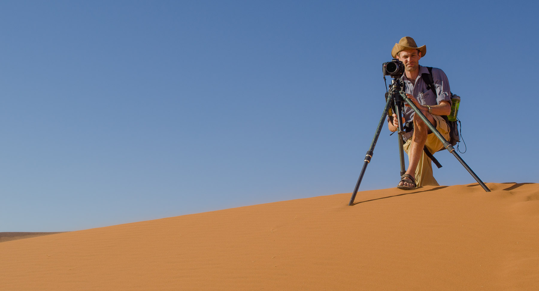 Man with a camera on a tripod in the desert