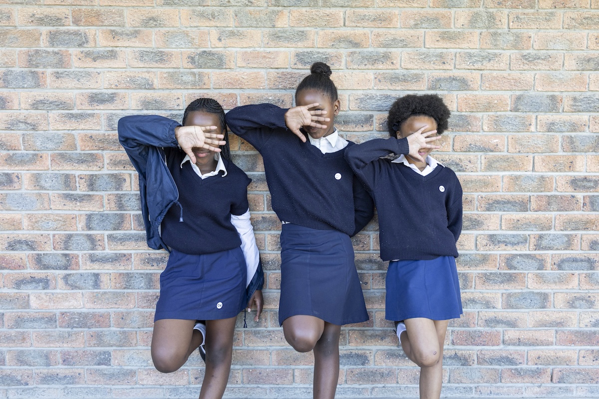 Three schoolgirls in uniform posing playfully