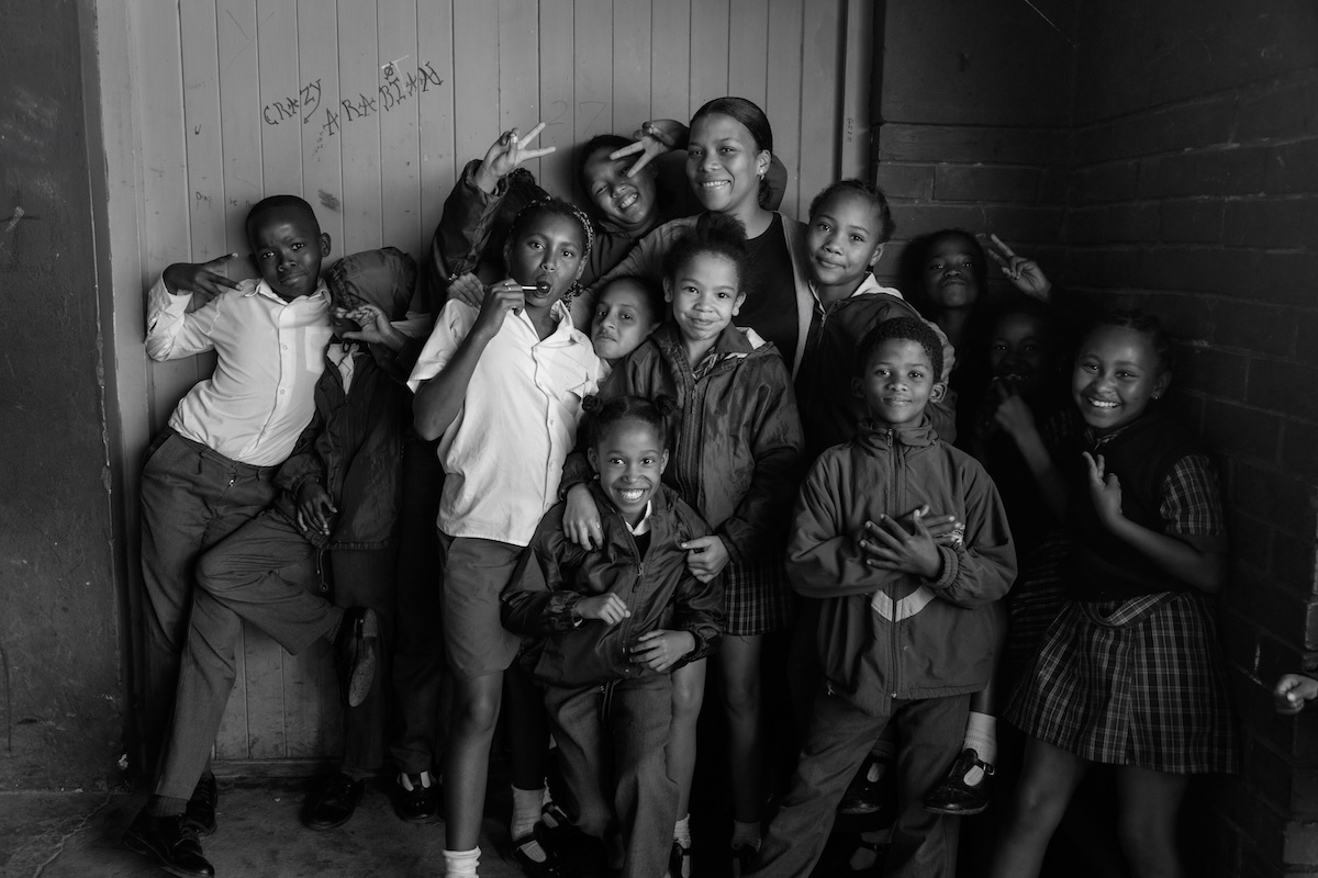 Group of smiling kids and a woman posing together