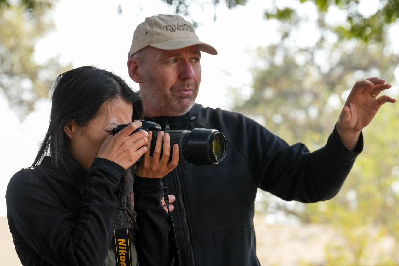 a woman holding a camera, while standing next to another person